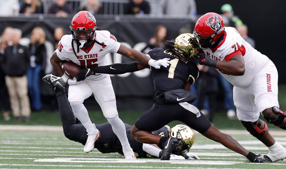 N.C. State wide receiver Keyon Lesane (15) looks to escape from Wake Forest defensive back Caelen Carson (1) as N.C. State offensive lineman Anthony Belton (74) blocks during the first half of N.C. State’s game against Wake Forest at Allegacy Stadium in Winston-Salem, N.C., Saturday, Nov. 11, 2023.