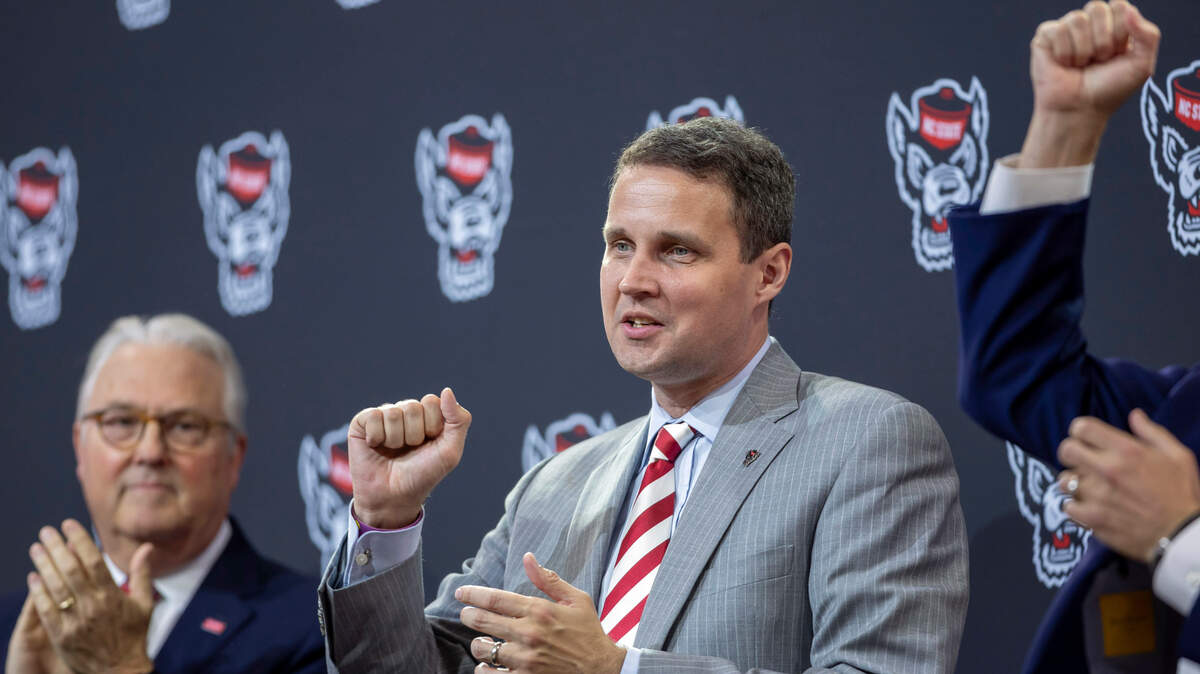 N.C. State Chancellor Randy Woodson, coach Will Wade and athletic director Boo Corrigan conclude their introduction of Wade as the new men’s basketball coach, with the Wolfpack fight song at Reynolds Coliseum on Tuesday, March 25, 2025 in Raleigh, N.C.