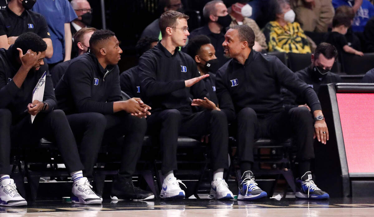 Duke associate head coach Chris Carrawell, right, congratulates associate head coach Jon Scheyer as time runs out during Duke’s 76-64 victory over Wake Forest at LJVM Coliseum in Winston-Salem, N.C., Wednesday, January 12, 2022. Assistant coach Nolan Smith is to the left.