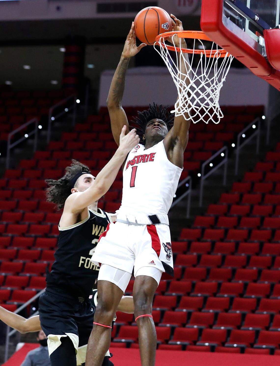 N.C. State’s Dereon Seabron (1) is fouled by Wake Forest’s Ismael Massoud (25) as he tries to slam in two during the second half of N.C. State’s 72-67 victory over Wake Forest at PNC Arena in Raleigh, N.C., Wednesday, January 27, 2021.