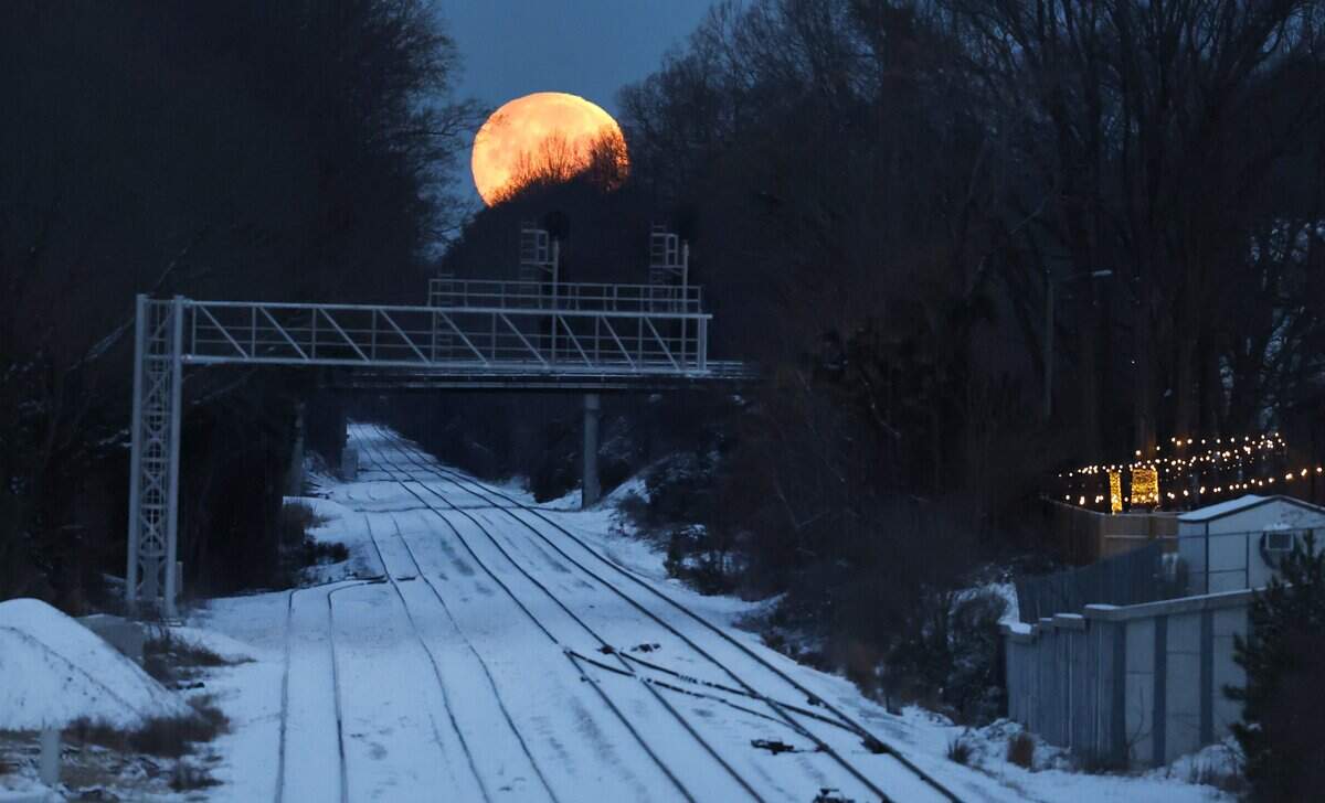 The moon sets as seen from the Boylan Avenue bridge in Raleigh, N.C., Sunday morning, Feb. 1, 2026.