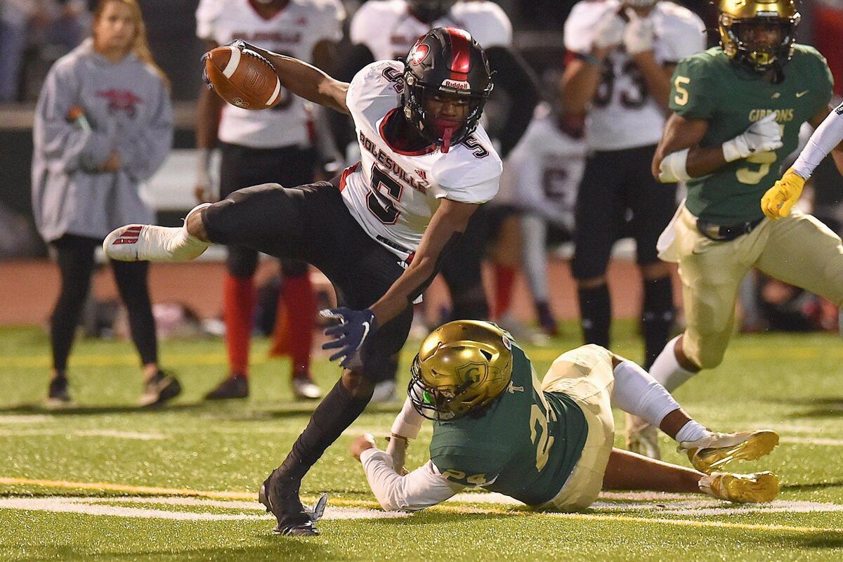 Rolesville’s Noah Rogers (5) scrambles for yardage past Cardinal Gibbons’ Ryan Ziegler (24) during the first half. The Cardinal Gibbons Crusaders and the Rolesville Rams met in the NCHSAA 4A East Regional Final in Raleigh, N.C. on December 3, 2021