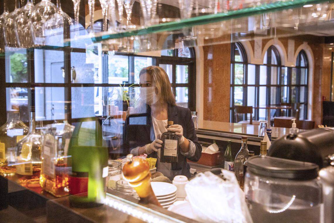 Annabel Butler, restaurant manager and sommelier at Il Palio, restocks liquor at the restaurant’s bar ahead of opening the following evening with 9 reservations under Gov. Roy Cooper’s Phase Two of reopening during the coronavirus pandemic, on Thursday, May 21, 2020, in Chapel Hill, N.C.