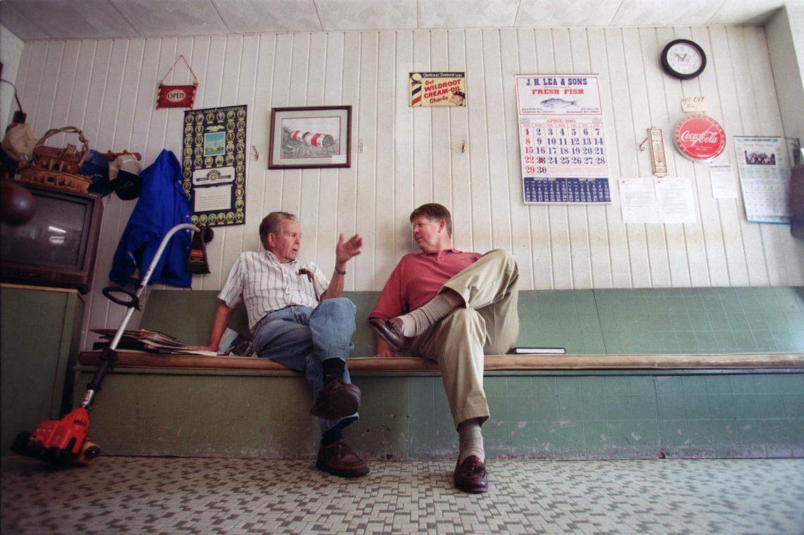 Senator Marc Basnight (right) talks with Bobby Mitchell at Mitchell’s barber shop in Columbia on a stop while heading back to Raleigh from Manteo in 2001.
