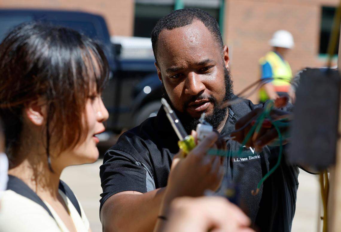 Otis Jackson with L.L. Vann Electric instructs Jalin Zheng, a rising junior at Panthers Creek High School, how to wire outlets during Construction Field Day at Bobbitt Design Build in Raleigh, N.C., Tuesday, July 19, 2022. The field day is part of WakeEd Partnership and Wake County Schools’ Career Accelerator, a two-week program to give students an opportunity for workplace learning experiences.