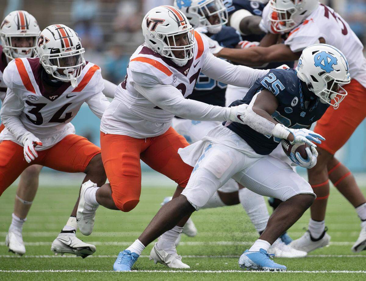 North Carolina’s Javonte Williams (25) turns the corner on Virginia Tech’s Armani Chatman (27) in the third quarter on Saturday, October 10, 2020 at Kenan Stadium in Chapel Hill, N.C.