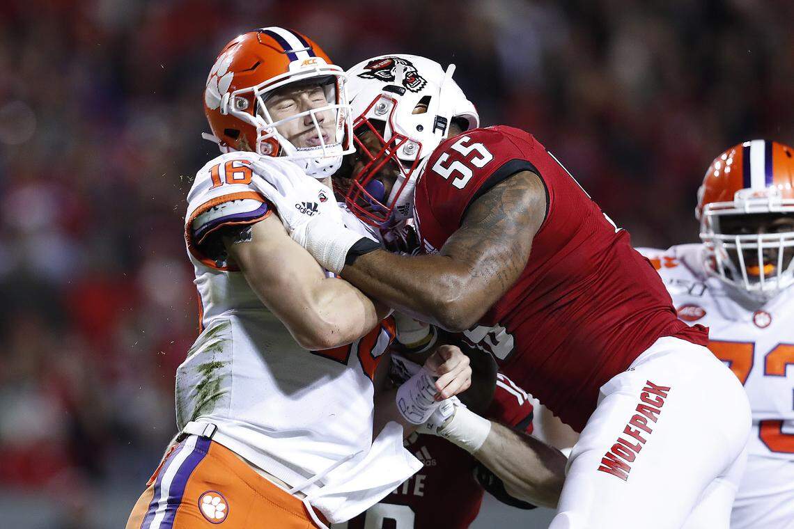Clemson quarterback Trevor Lawrence (16) is hit by N.C. State defensive end Deonte Holden (55) right after he completed his throw during the first half of N.C. State’s game against Clemson at Carter-Finley Stadium in Raleigh, N.C. Saturday, Nov. 9, 2019.