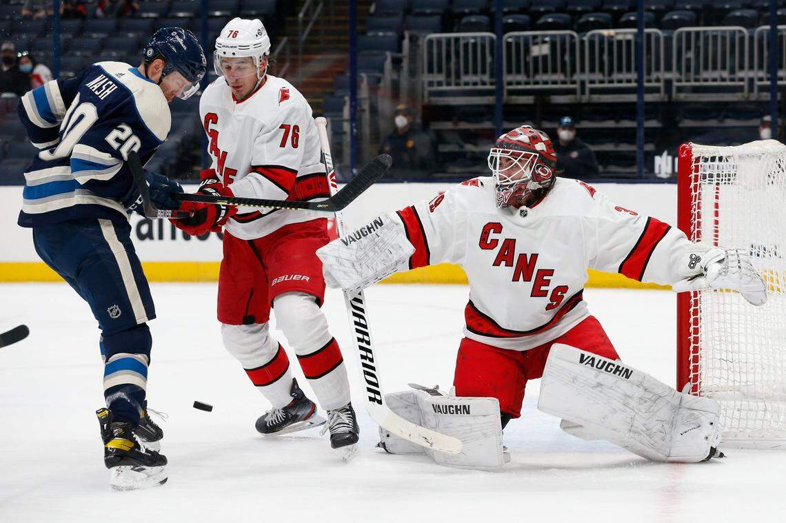 Carolina Hurricanes’ Alex Nedeljkovic, right, makes a save as teammate Brady Skjei, center, and Columbus Blue Jackets’ Riley Nash look for the puck during the second period of an NHL hockey game Monday, March 22, 2021, in Columbus, Ohio. (AP Photo/Jay LaPrete)