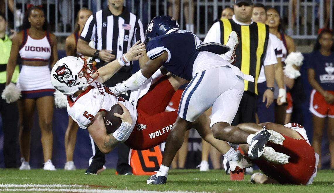 N.C. State quarterback Brennan Armstrong (5) heads into the end zone while being hit by Connecticut defensive back Stan Cross (4) on a 8-yard touchdown run during the second half of N.C. State’s 24-14 victory over UConn at Rentschler Field in East Hartford, Conn. Thursday, August 31, 2023.