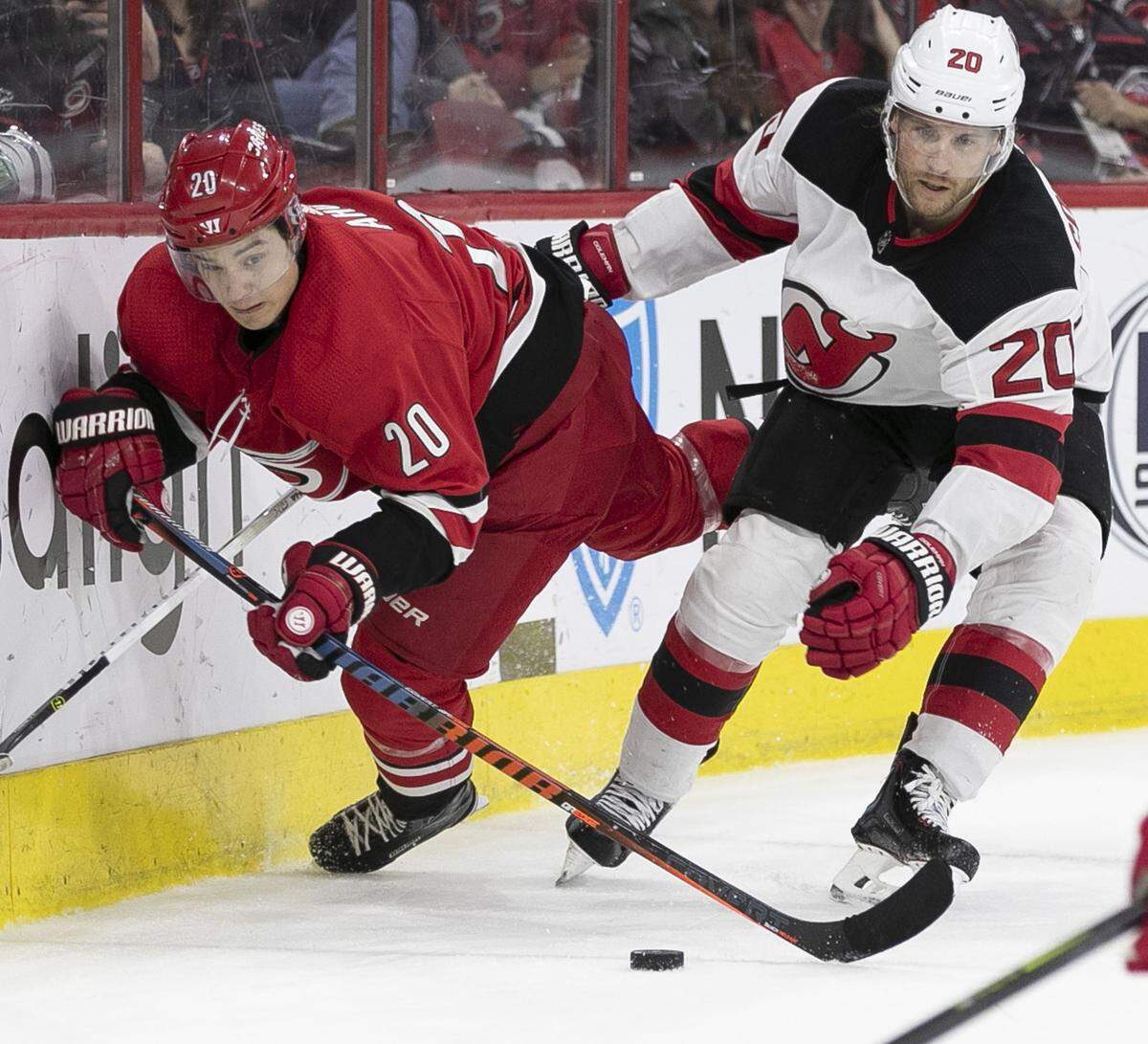 Carolina Hurricanes’ Sebastian Aho (20) and New Jersey’s Blake Coleman (20) chase down the puck behind the Devil’s goal in the second period on Thursday, April 4, 2019 at the PNC Arena in Raleigh, N.C.