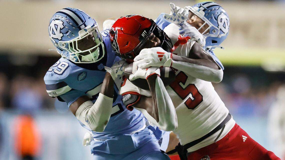 N.C. State wide receiver Noah Rogers (5) pulls in a 44-yard reception while being defended North Carolina’s Marcus Allen (29) and Will Hardy (31) late in the fourth quarter of N.C. State’s 35-30 victory over UNC at Kenan Stadium in Chapel Hill, N.C., Saturday, Nov. 30, 2024.
