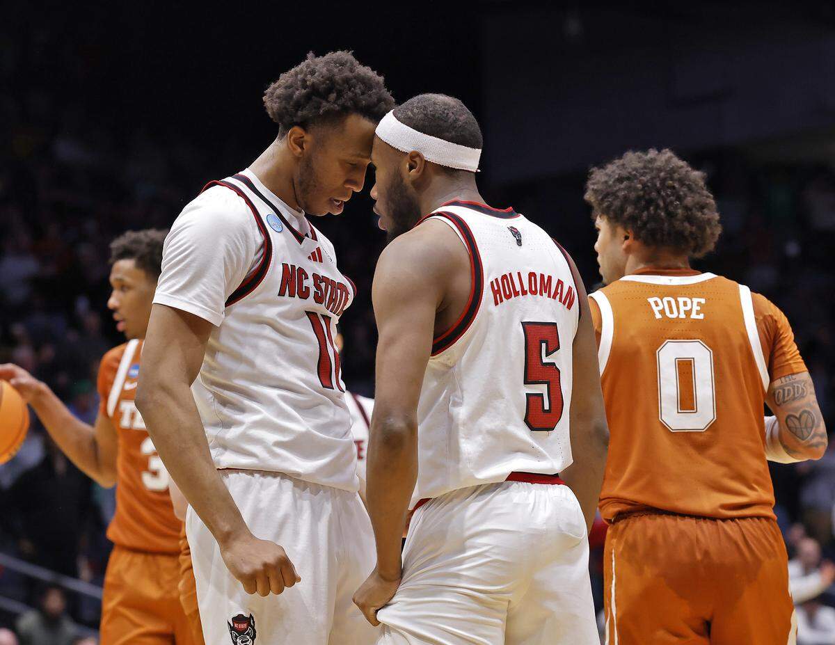 N.C. State’s Quadir Copeland speaks with teammate Tre Holloman after Holloman drew a foul with less than a minute remaining in the Wolfpack’s 68-66 loss to Texas in the NCAA First Four on Tuesday, March 17, 2026, at the University of Dayton Arena in Dayton, Ohio. 