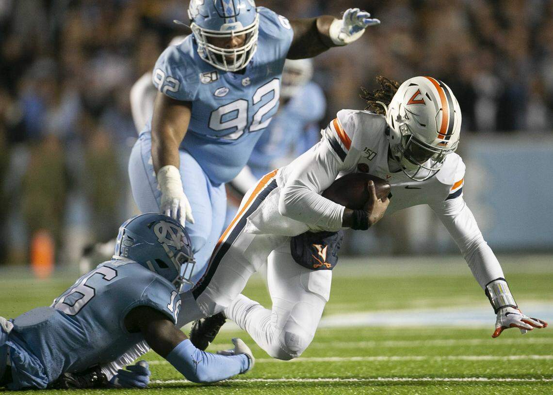 Virginia quarterback Bryce Perkins (3) is sacked on third down for a seven yard loss in the second quarter by North Carolina’s D.J. Ford (16) on Saturday, November 2, 2019 at Kenan Stadium in Chapel Hill, N.C.