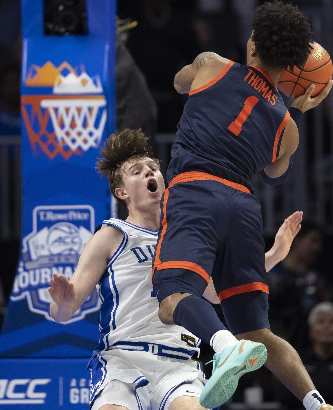 Duke guard Nikolas Khamenia (14) is called for blocking as Virginia guard Malik Thomas (1) drives to the basket in the first half on Saturday, March 14, 2026, during the ACC Tournament Championship at Spectrum Center in Charlotte, N.C.