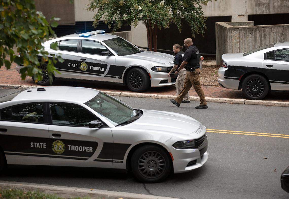 Law enforcement walk along South Road while responding to an “active assailant situation” on the campus of UNC-Chapel Hill on Monday, Aug. 28, 2023.