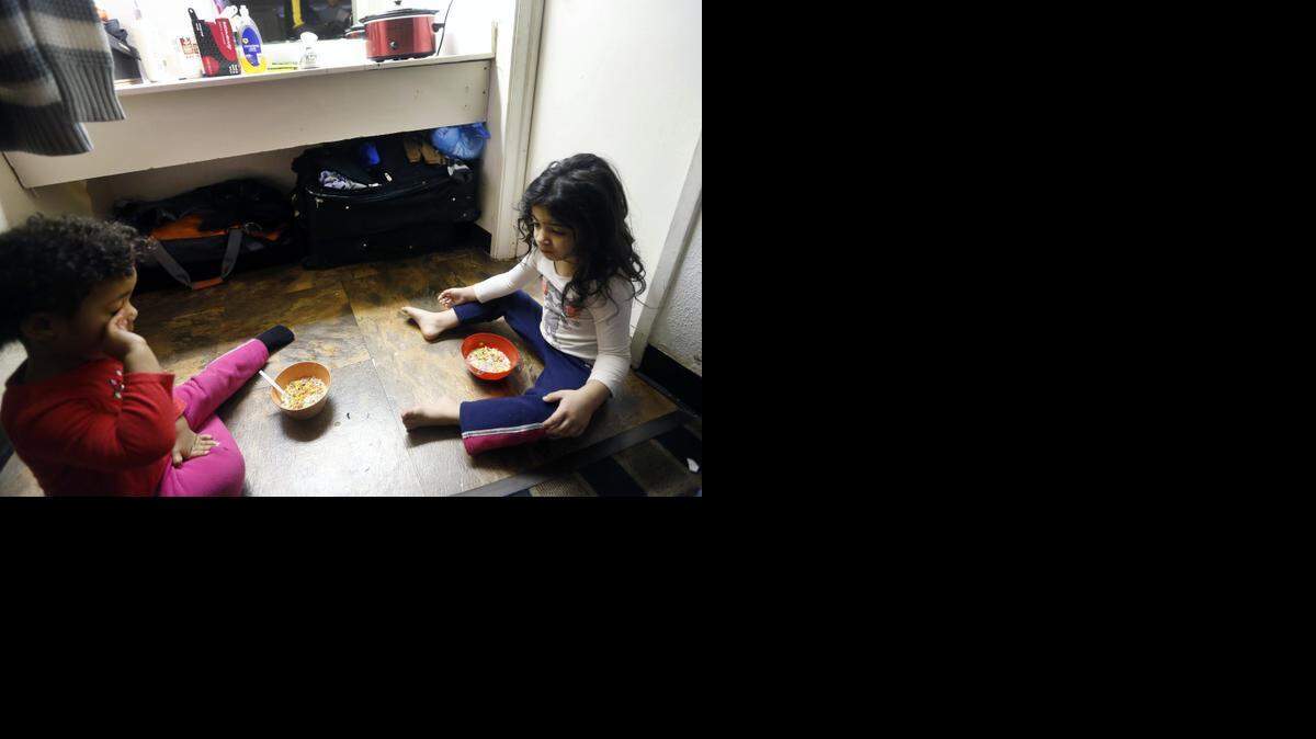 April Carroll’s daughters Naomi, 2, left, and Neveah, 4, eat breakfast on the floor by their bathroom in their room at the Raleigh Inn in this 2015 file photo. The Wake County school system has seen an 88% increase in the past decade in the number of homeless students, including those living in motels.