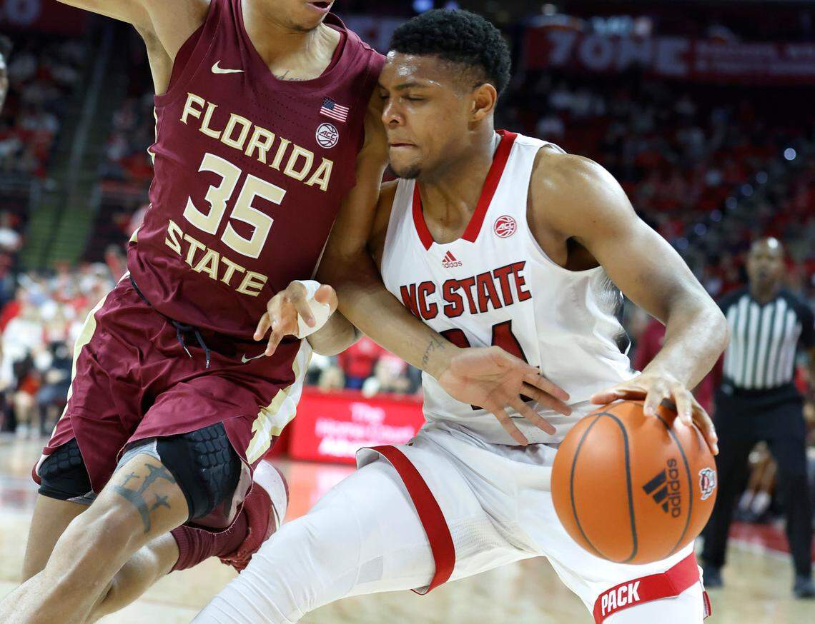N.C. State’s Casey Morsell (14) drives by Florida State’s Matthew Cleveland (35) during the second half of N.C. State’s 94-66 victory over FSU at PNC Arena in Raleigh, N.C., Wednesday, Feb. 1, 2023.