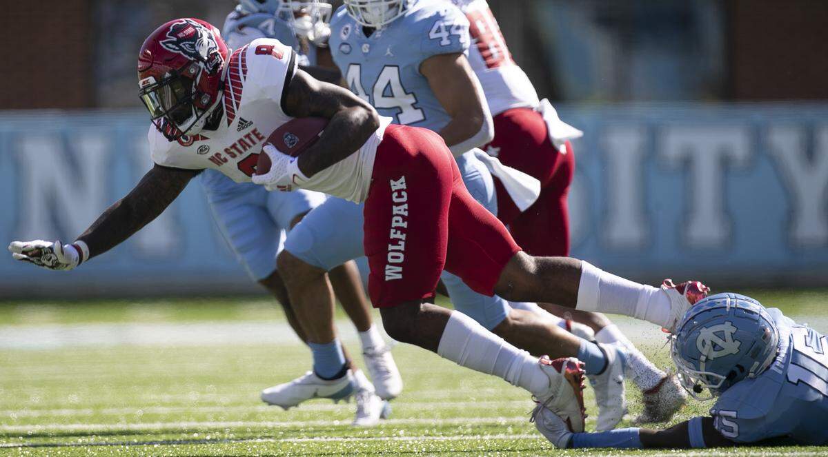 North Carolina’s Ladaeson Hollins (15) stops N.C. State’s Ricky Person Jr. (8) in the first quarter at Kenan Stadium on Saturday, October 24, 2020 in Chapel Hill, N.C.