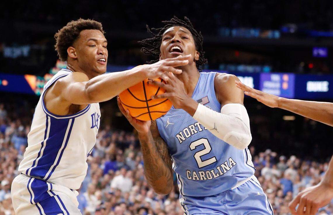 North Carolina’s Caleb Love (2) drives past Dukes Wendell Moore Jr. (0) during the first half of Dukes game against UNC in the Final Four at Caesars Superdome in New Orleans, La., Saturday, April 2, 2022.