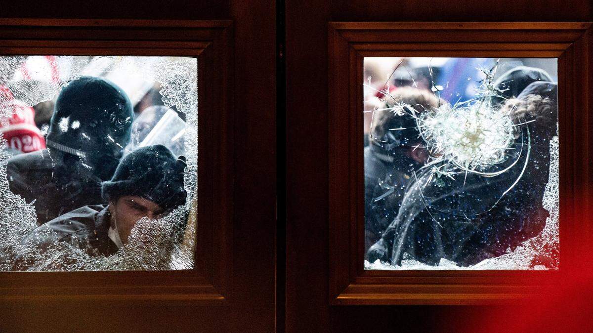 Seguidores de Donald Trump amotinados rompen ventanas para tratar de entrar al Capitolio de Estados Unidos, el 6 de enero de 2021 en Washington D.C.