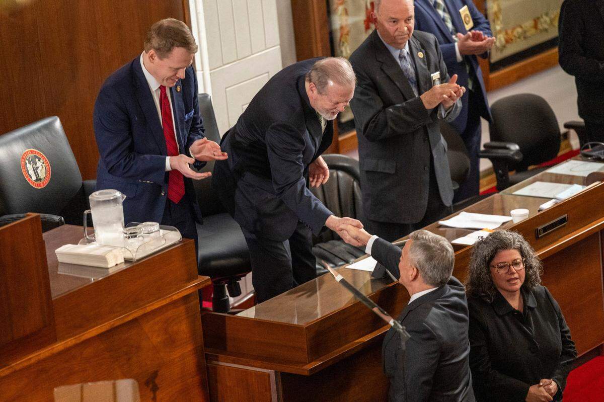 Gov. Josh Stein is greeted by House Speaker Destin Hall, left, and shakes hands with Senate leader Phil Berger, right, before delivering his State of the State address to a joint session of the General Assembly on Wednesday, March 12, 2025, in the House chamber of the Legislative Building.
