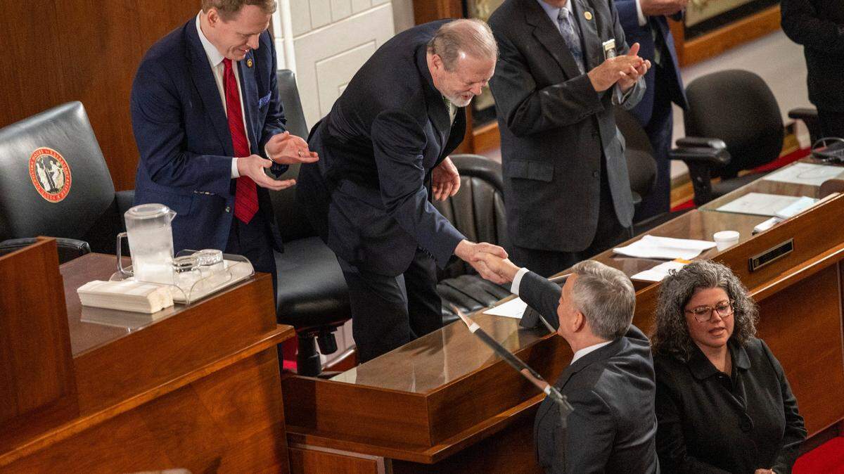 Gov. Josh Stein is greeted by House Speaker Destin Hall, left, and shakes hands with Senate leader Phil Berger, right, before delivering his State of the State address to a joint session of the General Assembly on March 12, 2025, in the House chamber of the Legislative Building.