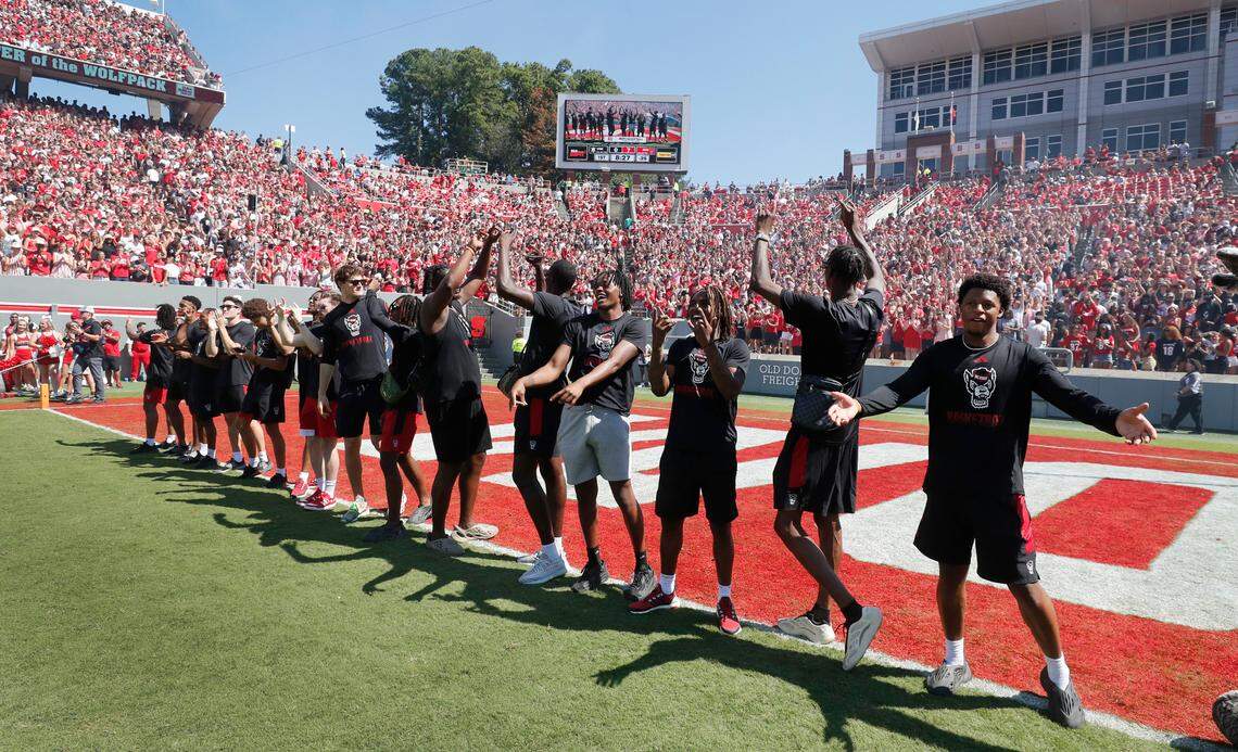 N.C. State men’s basketball players, from left, Breon Pass, Casey Morsell, KJ Keatts, Michael O’Connell, Jordan Snell, Jayden Taylor, Alex Nunnally, Ben Middlebrooks, DJ Horne, DJ Burns, Mohamed Diarra, Dennis Parker, Jr., Kam Woods, Ernest Ross and LJ Thomas respond to the crowd as they are introduced during the Wolfpack’s football game against VMI at Carter-Finley Stadium in Raleigh, N.C., Saturday, Sept. 16, 2023.