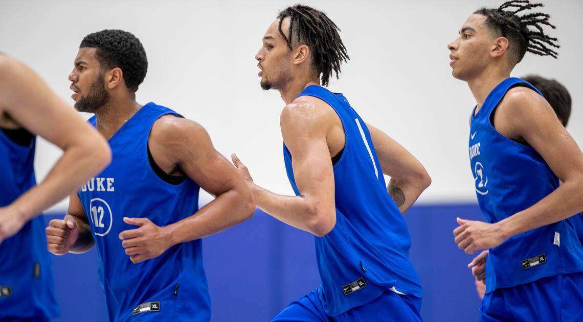 Duke freshmen Kale Catchings (12), Dereck Lively II (1) and Christian Reeves (21) warm up for the Blue Devils’ second practice of the season on Tuesday, September 27, 2022 in Durham, N.C.