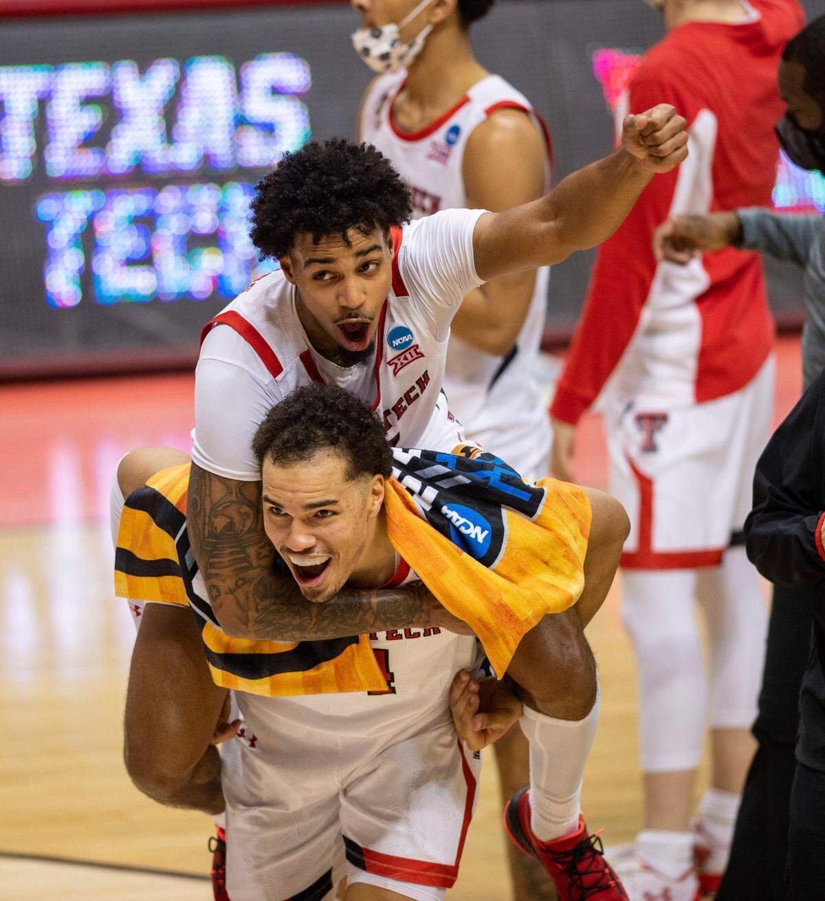 Texas Tech guard Kyler Edwards (11) catches a ride on the back of teammate forward Marcus Santos-Silva (14) as the two celebrate their win over Utah State in a first round game in the NCAA men’s college basketball tournament, Friday, March 19, 2021, at Assembly Hall in Bloomington, Ind. 