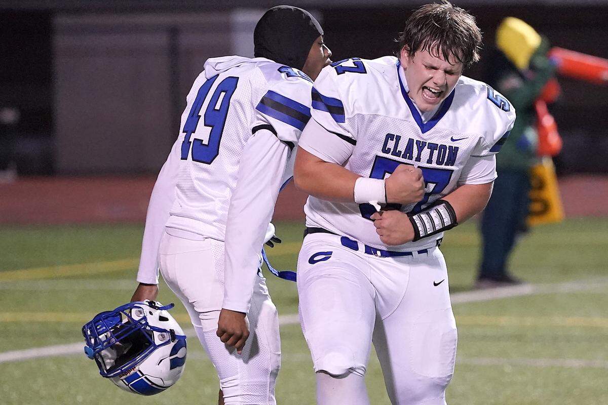 Clayton's Wesson Barth (57) and Darnell Hawkins (49) celebrate their close victory over Cardinal Gibbons to win the 7A East Regional Final. The Clayton Comets and the Cardinal Gibbons Crusaders met in the East Regional Final of the NCHSAA 7A Football Championship in Clayton, N.C. on December 4, 2025.