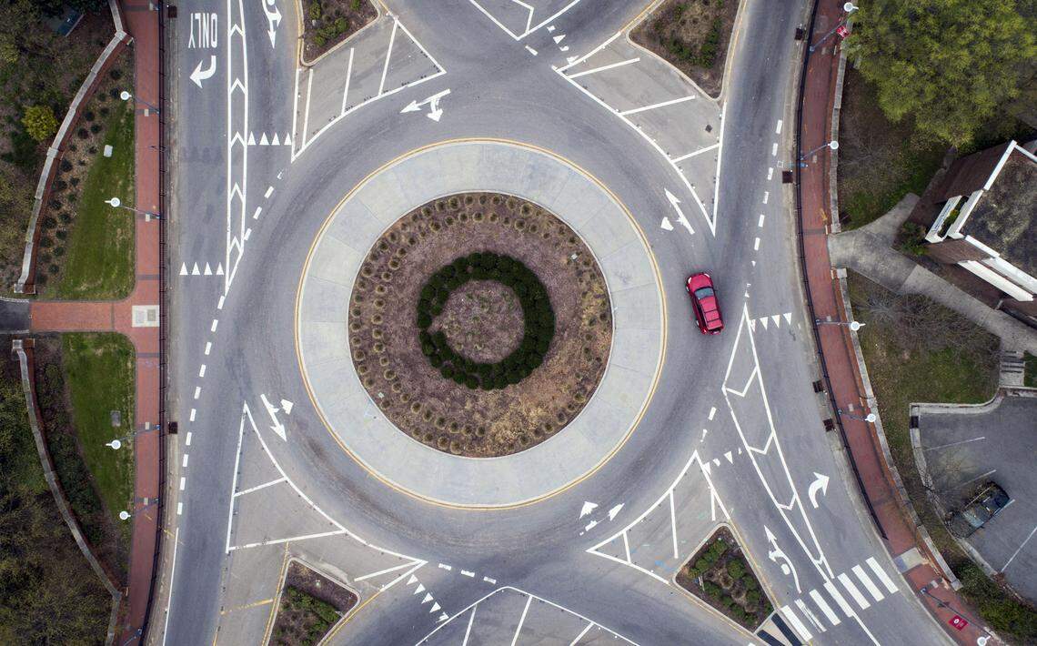 One car drives through what is normally a packed traffic circle in front of N.C. State’s Bell Tower on Friday, March 27, 2020 around noon. A Stay-At-Home Order for Wake County goes into effect Friday evening at 5 p.m.
