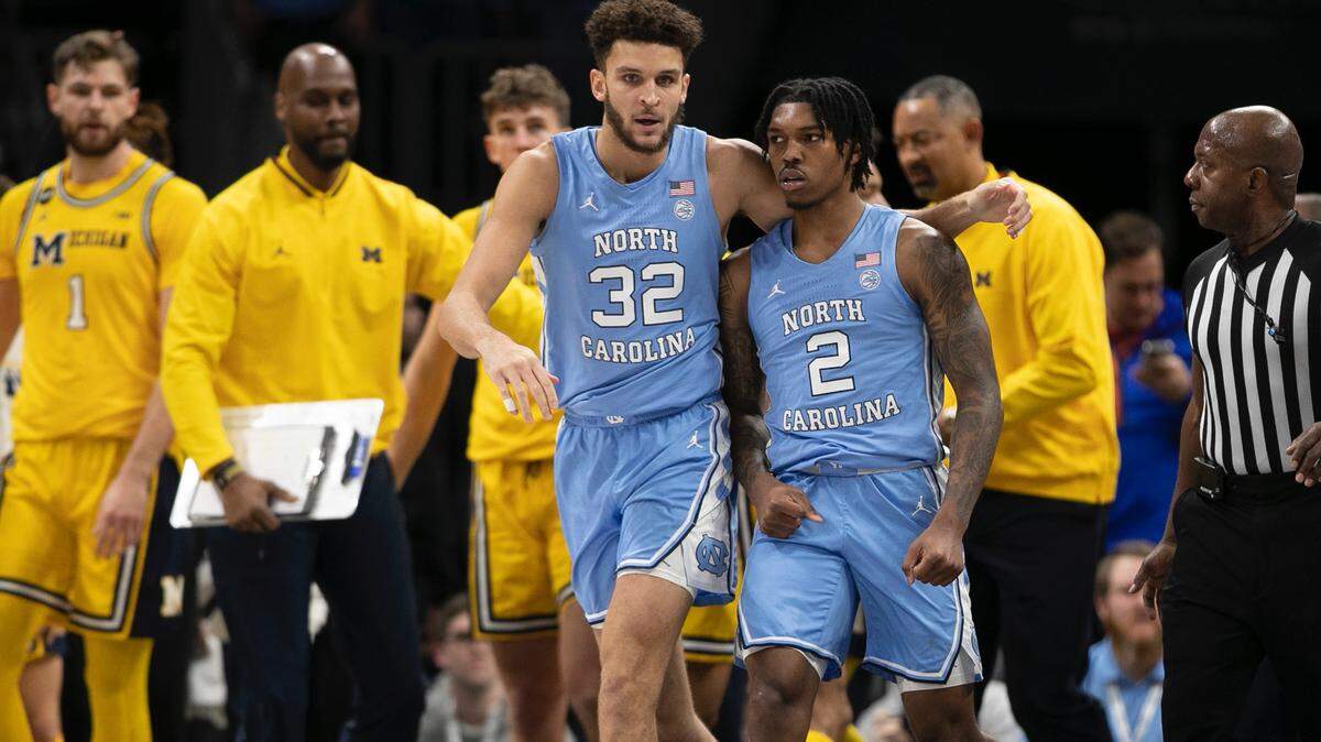 North Carolina’s Pete Nance (32) consoles Caleb Love (2) after Love and a Michigan player drew technical fouls in the first half on Wednesday, December 21, 2022 at the Spectrum Center in Charlotte, N.C.
