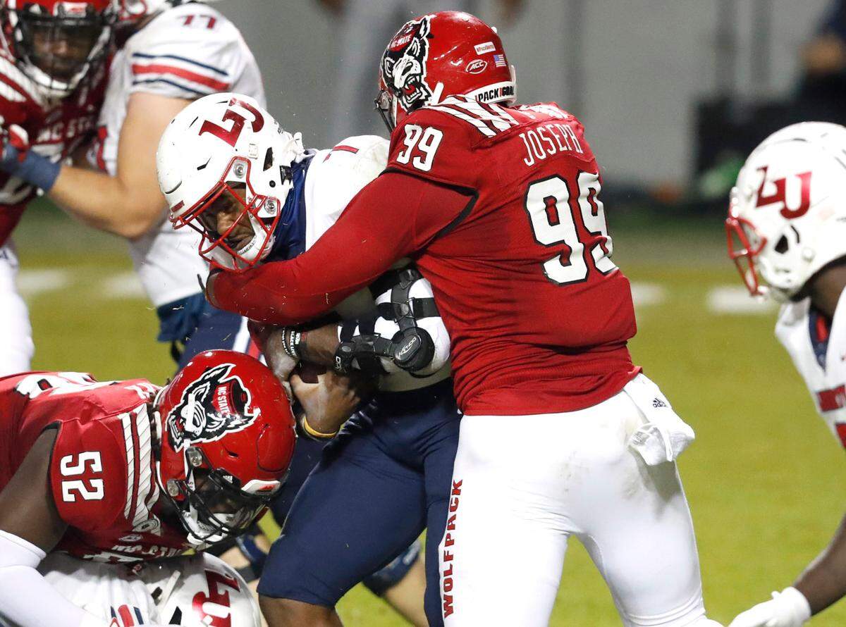 N.C. State’s Daniel Joseph (99) sacks Liberty quarterback Malik Willis (7) during the first half of N.C. State’s game against Liberty at Carter-Finley Stadium in Raleigh, N.C., Saturday, Nov. 21, 2020.