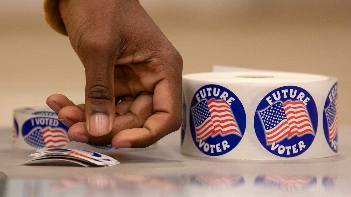 A person prepares stickers for voters at Aversboro Elementary School in Garner on March 5, 2024.