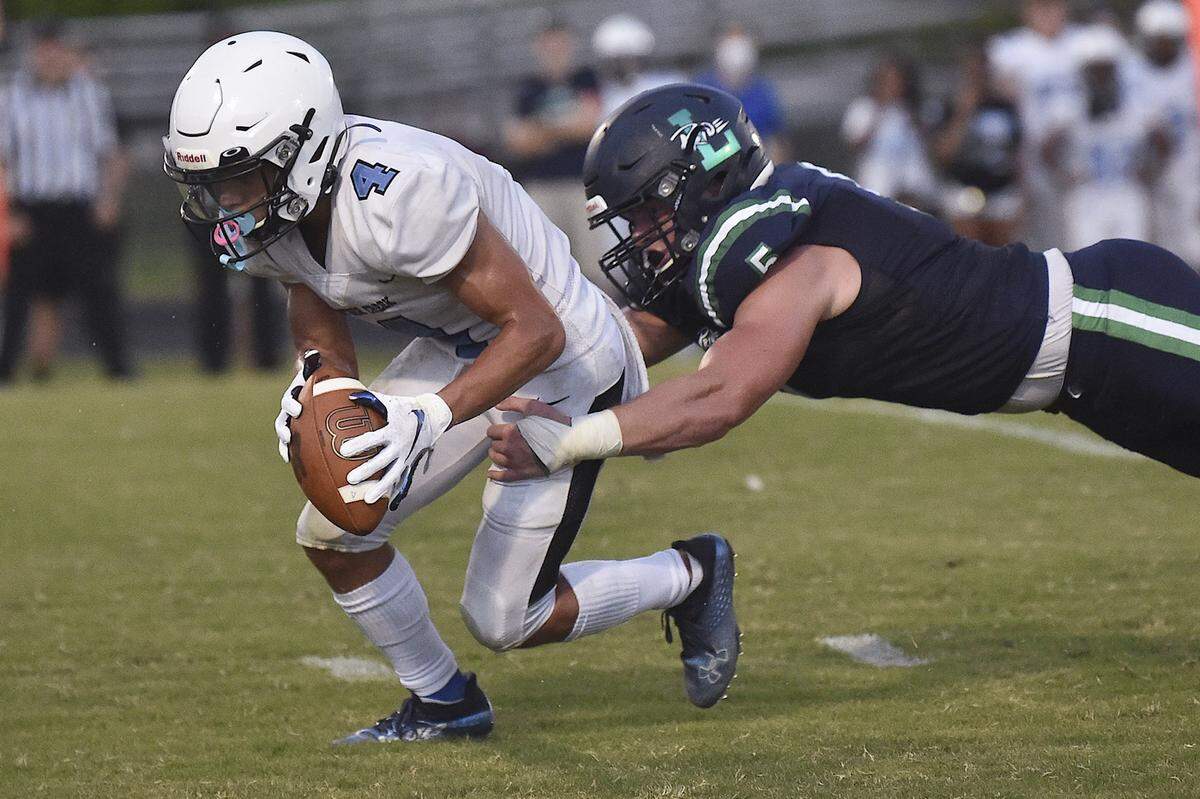 Leesville Road’s Beau Atkinson (5) grapples Panther Creek’s Bradley Garrity (4) after recovering the loose ball. The Leesville Pride and the Panther Creek Catamounts met in a football game in Raleigh, N.C. on August 27, 2021.