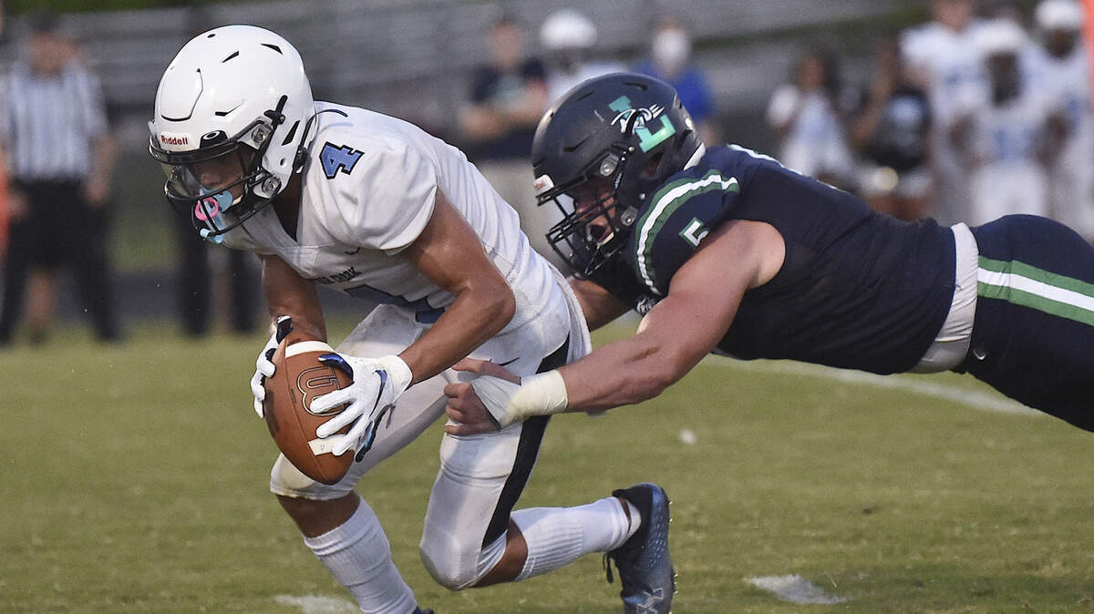 Leesville Road’s Beau Atkinson (5) grapples Panther Creek’s Bradley Garrity (4) after recovering the loose ball. The Leesville Pride and the Panther Creek Catamounts met in a football game in Raleigh, N.C. on August 27, 2021.