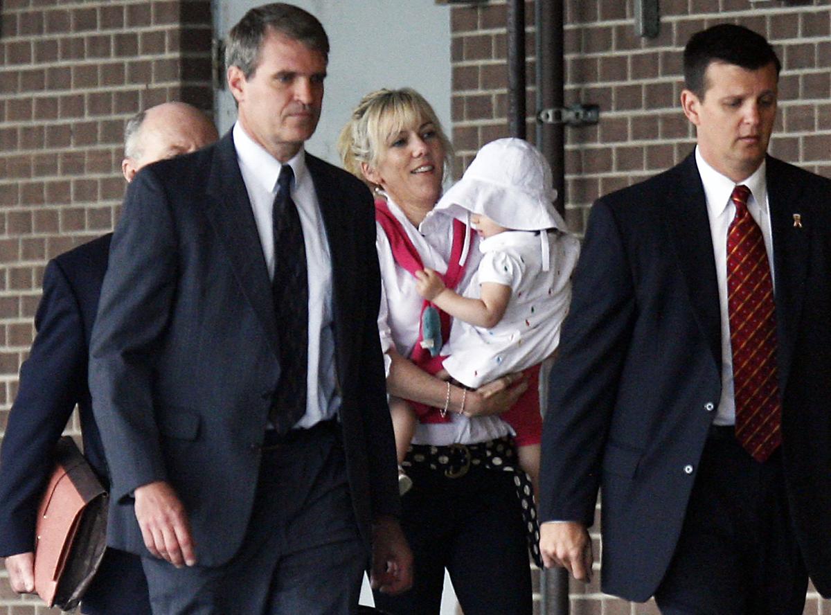 2009-John Edwards’ former mistress Rielle Hunter enters the Terry Sanford Federal Building in Raleigh, NC, holding a baby and accompanied by escorts to testify about Edwards’ campaign expenditures on Thursday, Aug. 6, 2009.