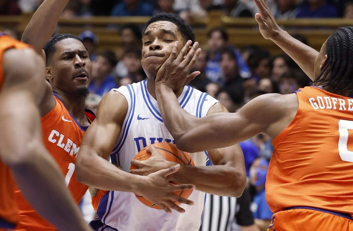 Duke’s Caleb Foster (1) is defended by Clemson's RJ Godfrey (0), right, and Jestin Porter (1) during the first half of Duke’s game against Clemson at Cameron Indoor Stadium in Durham, N.C., Sat., Feb. 14, 2026.