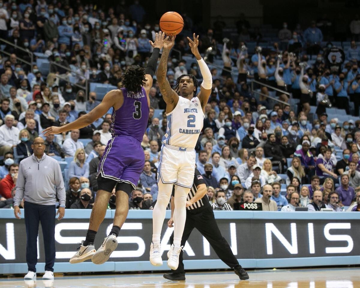 North Carolina’s Leaky Black (1) launches a three-point shot over Furman’s Mike Bothwell (3) during the second half on Tuesday, December 14, 2021 at the Smith Center in Chapel Hill, N.C.