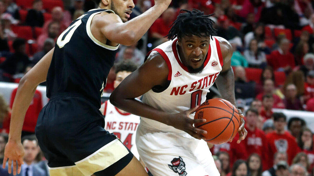 N.C. State’s D.J. Funderburk (0) drives around Wake Forest’s Olivier Sarr (30) during the first half of the N.C. State Wolfpack’s game against the Wake Forest Demon Deacons at PNC Arena in Raleigh, N.C., Friday, March 6, 2020.