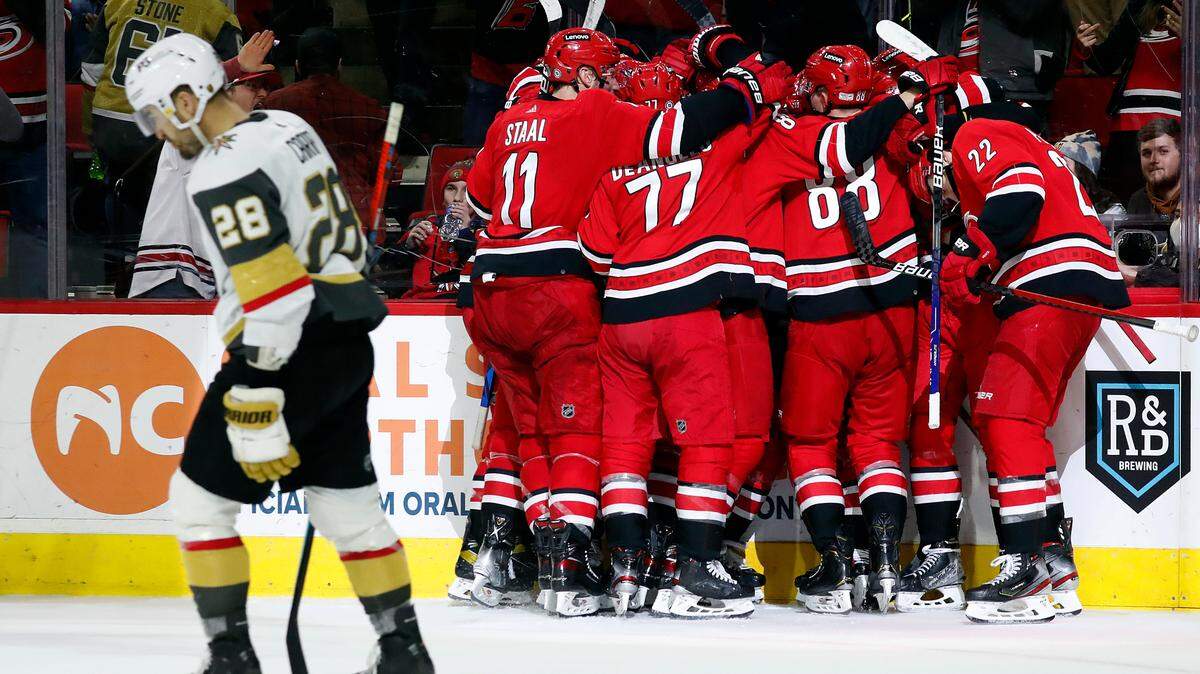 The Carolina Hurricanes celebrate an overtime goal by Sebastian Aho as Vegas Golden Knights’ William Carrier (28) skates by during an NHL hockey game in Raleigh, N.C., Tuesday, Jan. 25, 2022. (AP Photo/Karl B DeBlaker)