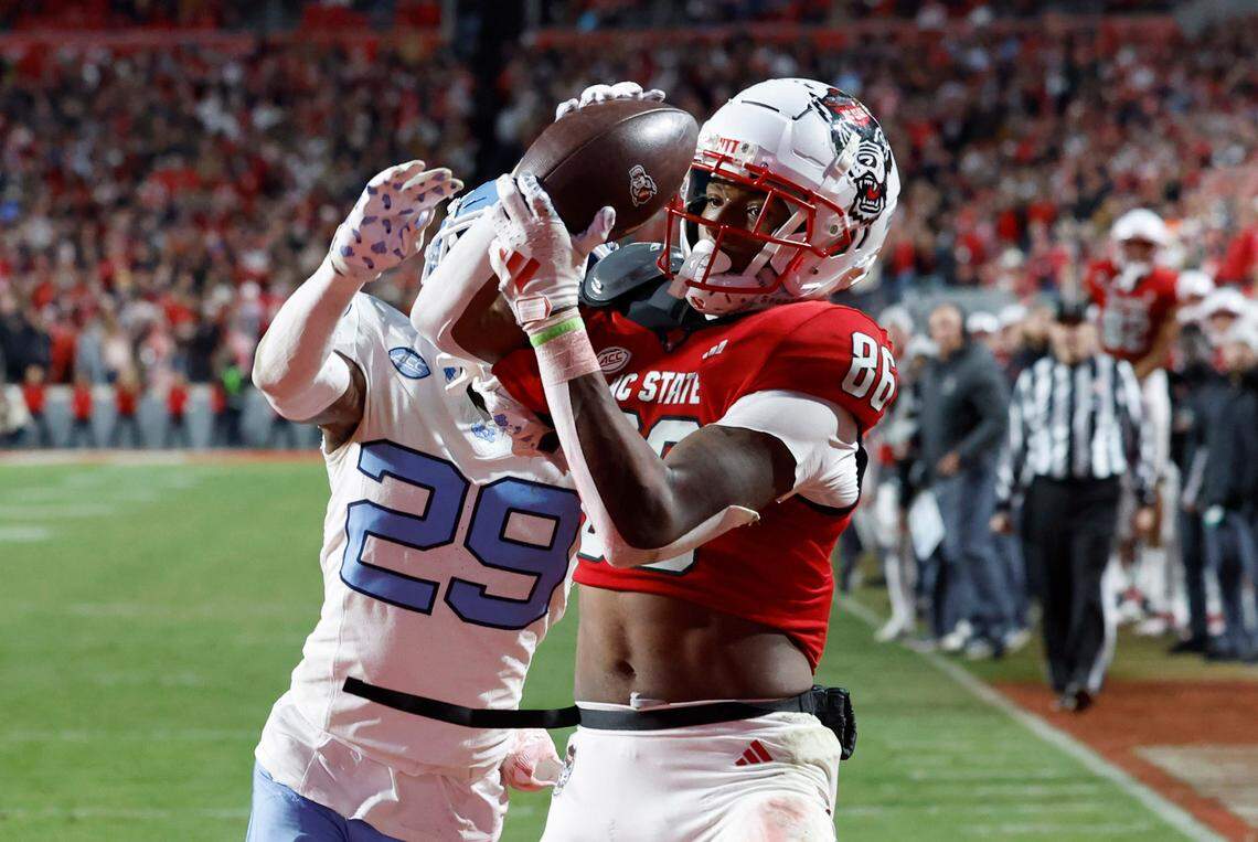 N.C. State wide receiver Dacari Collins (86) pulls in a 20-yard touchdown reception as North Carolina defensive back Marcus Allen (29) defends during the second half of N.C. State’s 39-20 victory over UNC at Carter-Finley Stadium in Raleigh, N.C., Saturday, Nov. 25, 2023.