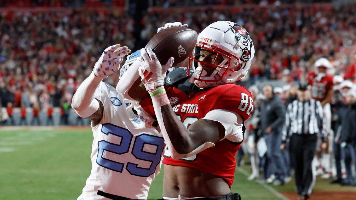 N.C. State wide receiver Dacari Collins (86) pulls in a 20-yard touchdown reception as North Carolina defensive back Marcus Allen (29) defends during the second half of N.C. State’s 39-20 victory over UNC at Carter-Finley Stadium in Raleigh, N.C., Saturday, Nov. 25, 2023.