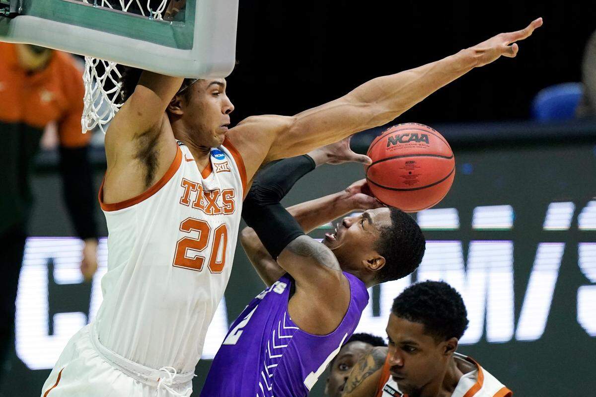 Texas’ Jericho Sims (20) blocks the path of Abilene Christian’s Mahki Morris during the first half of a college basketball game in the first round of the NCAA tournament at Lucas Oil Stadium in Indianapolis Saturday, March 20, 2021. 