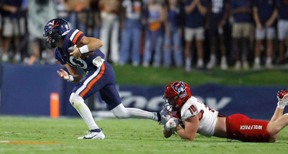 Virginia quarterback Anthony Colandrea (10) escapes N.C. State linebacker Caden Fordham (10) during the first half of N.C. State’s game against Virginia at Scott Stadium in Charlottesville, Va., Friday, Sept. 22, 2023.