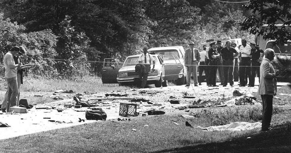Law enforcement officers investigate the scene where Fritz Klenner’s Chevy Blazer blew up during a police chase, killing himself, Susie Newsom Lynch and her two children on June 3, 1985.