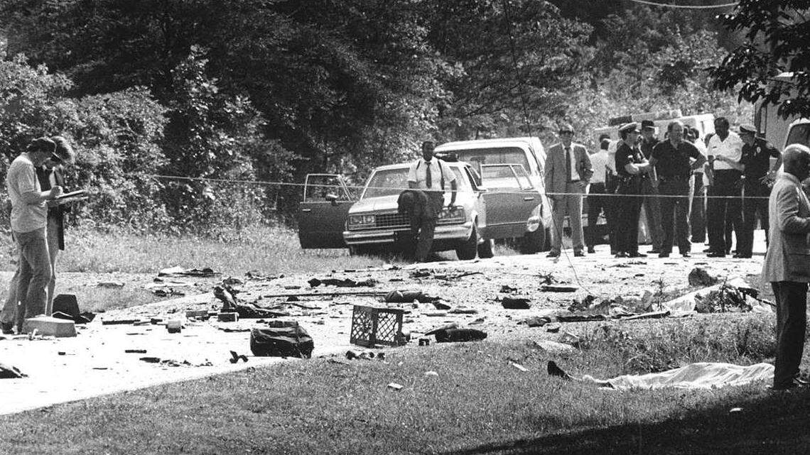 Law enforcement officers investigate the scene where Fritz Klenner’s Chevy Blazer blew up during a police chase, killing himself, Susie Newsom Lynch and her two children on June 3, 1985.