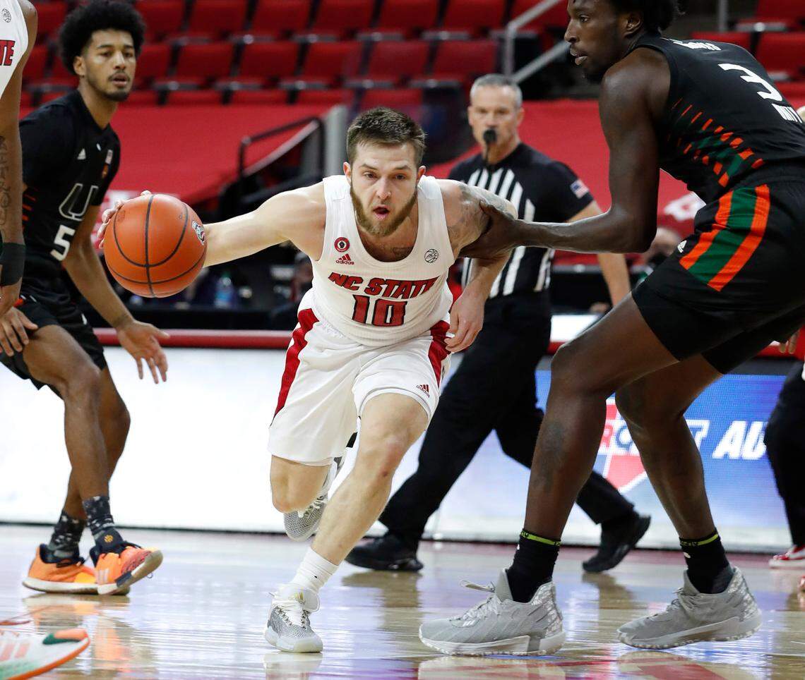 N.C. State’s Braxton Beverly (10) drives around Miami’s Nysier Brooks (3) during the second half of Miami’s 64-59 victory over N.C. State at PNC Arena in Raleigh, N.C., Saturday, January 9, 2021.