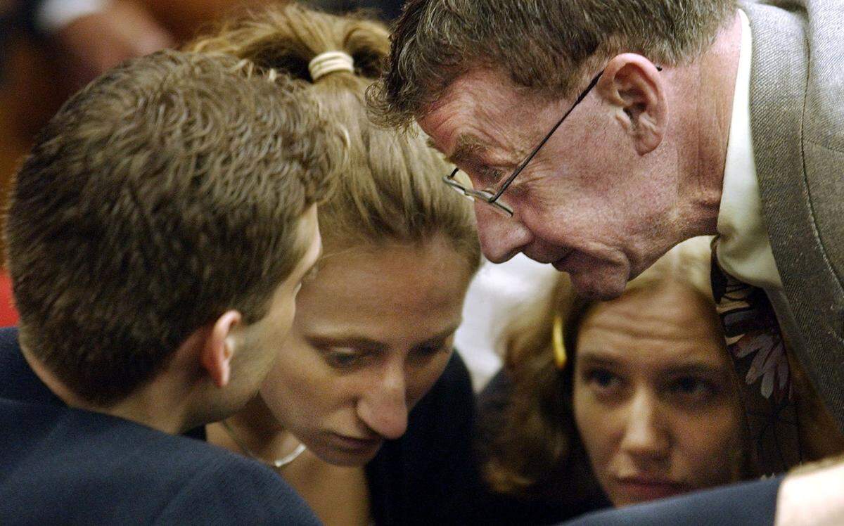 Murder defendant Michael Peterson, right, huddles with his children during a break in court during his murder trial Tuesday, July 15, 2003, in Durham, N.C. Left to right are Todd Peterson, Margaret Ratliff and Martha Ratliff.