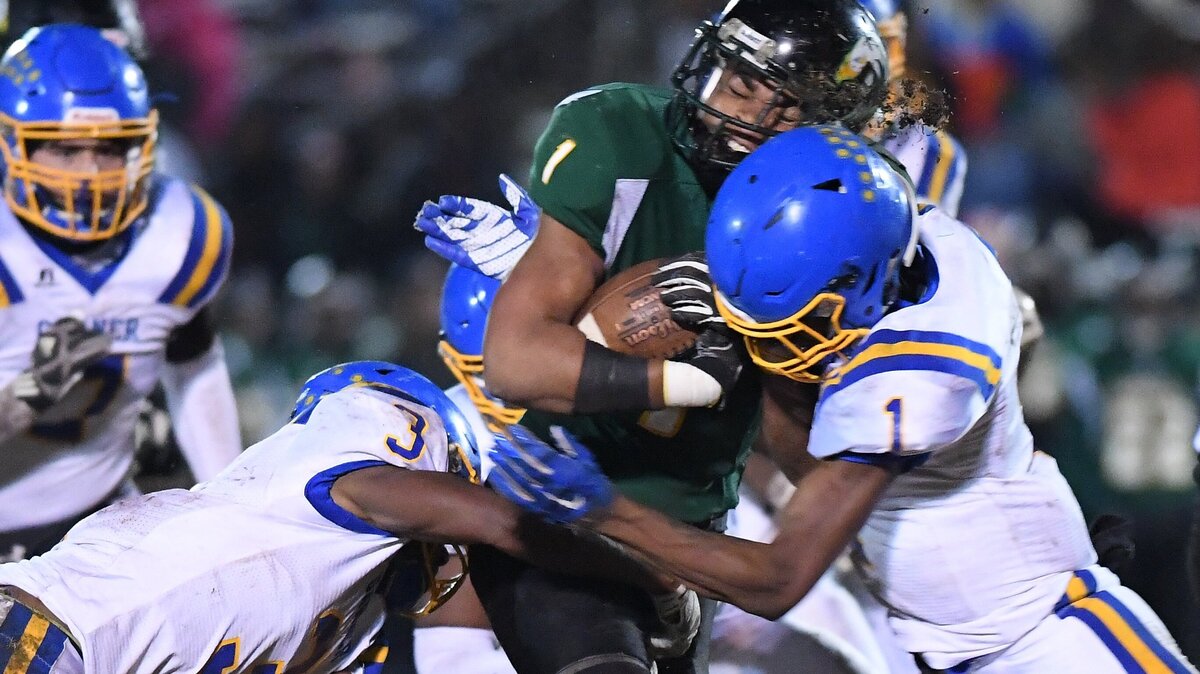 Hamilton Moore (1) of Enloe is tackled by Laytavion Haywood (1) and Daiveon Carrington (3) of Garner. The Garner Trojans visited the Enloe Eagles in a high school football game on November 16, 2018.